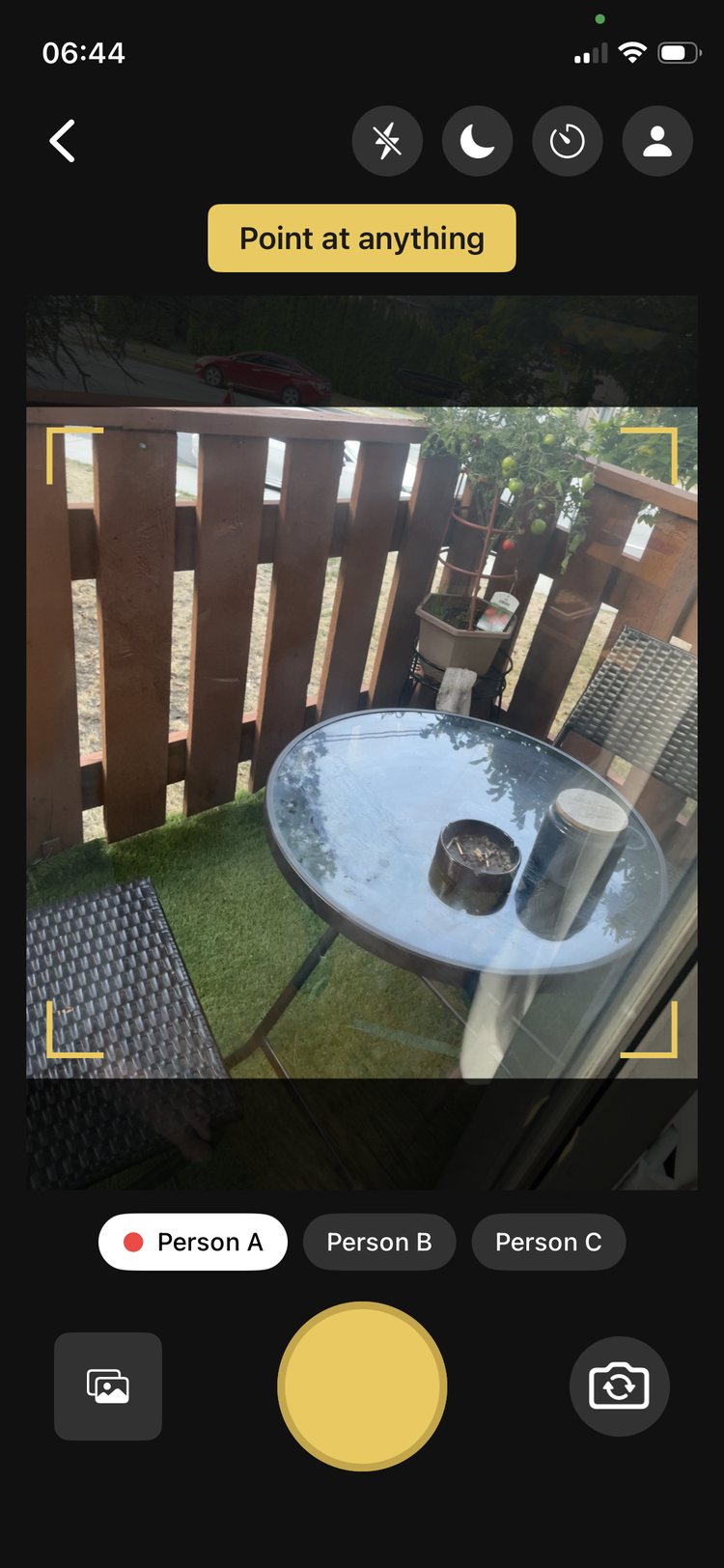 The Nani Sore camera screen pointed at a patio table, with a 'Point at anything' prompt and Person A, Person B, Person C tagging chips along the bottom.